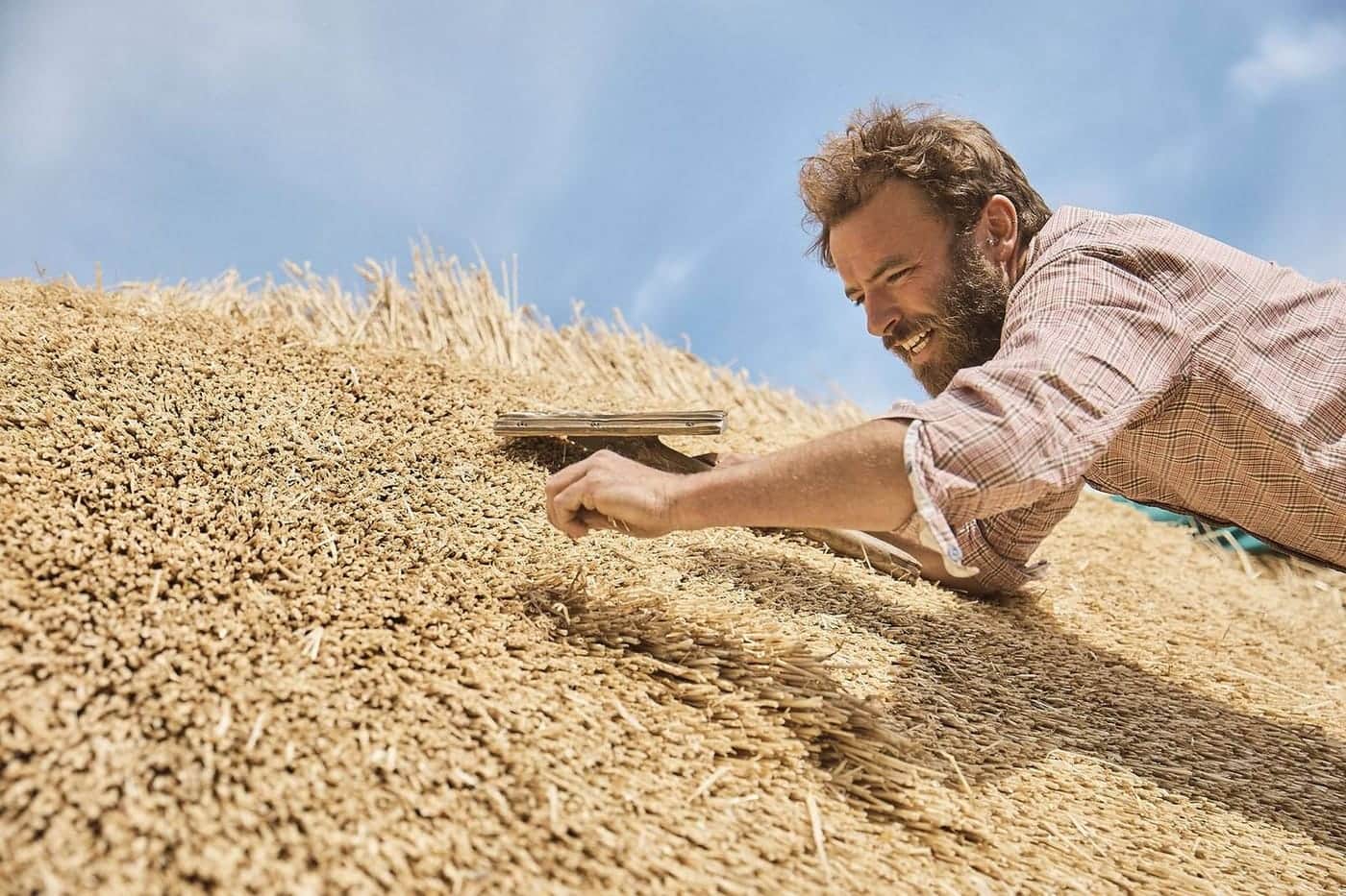 Christopher Keelty, master thatcher based in Frome, Somerset, working on a thatched roof